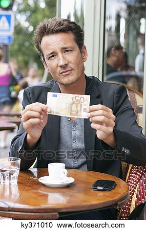 Man showing a 50 Euro banknote in a restaurant, Paris, Ile-de-France, France View Large Photo Image Stock Image - Man showing a 50 Euro banknote in a restaurant, Paris, Ile-de-France, France. Fotosearch