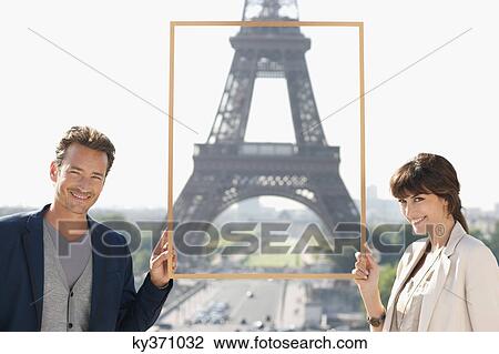 Stock Image - Portrait of a couple framing their dream vacation with Eiffel Tower, Paris, Ile-de-France, France. Fotosearch