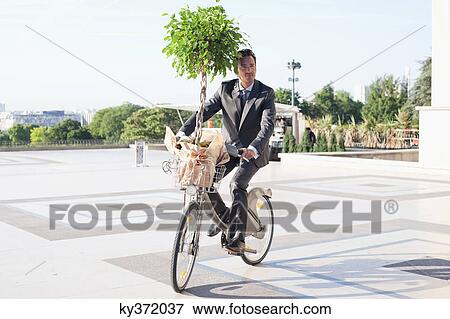 Businessman carrying a plant on a bicycle, Eiffel Tower, Paris, Ile-de-France, France View Large Photo Image Stock Photo - Businessman carrying a plant on a bicycle, Eiffel Tower, Paris, Ile-de-France, France. Fotosearch