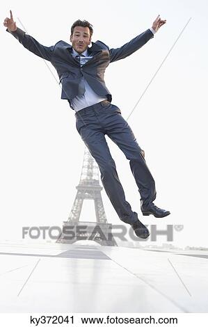 Stock Image - Businessman jumping with the Eiffel Tower in the background, Paris, Ile-de-France, France. Fotosearch