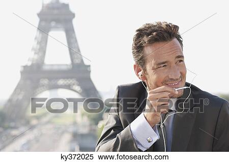 Businessman using a hands-free device with the Eiffel Tower in the background, Paris, Ile-de-France, France View Large Photo Image Stock Photography - Businessman using a hands-free device with the Eiffel Tower in the background, Paris, Ile-de-France, France. Fotosearch