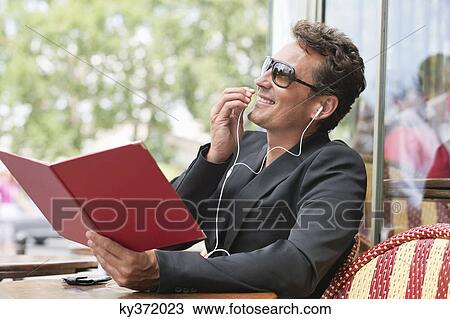 Man holding a menu and talking on a mobile phone in a restaurant, Paris, Ile-de-France, France View Large Photo Image Stock Image - Man holding a menu and talking on a mobile phone in a restaurant, Paris, Ile-de-France, France. Fotosearch