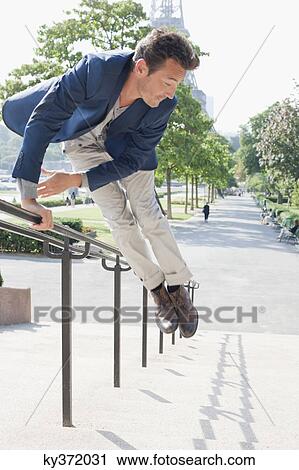 Man jumping across handrail of steps, Eiffel Tower, Paris, Ile-de-France, France View Large Photo Image Stock Image - Man jumping across handrail of steps, Eiffel Tower, Paris, Ile-de-France, France. Fotosearch