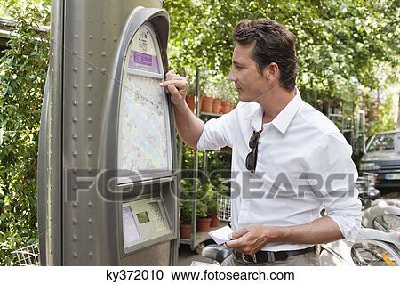 Man looking a map in a ticket machine, Paris, Ile-de-France, France View Large Photo Image Stock Image - Man looking a map in a ticket machine, Paris, Ile-de-France, France. Fotosearch
