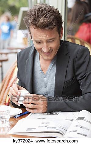 Man reading a magazine in a restaurant, Paris, Ile-de-France, France View Large Photo Image Picture - Man reading a magazine in a restaurant, Paris, Ile-de-France, France. Fotosearch