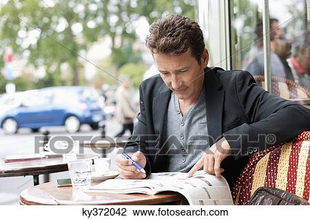 Man reading a magazine in a restaurant, Paris, Ile-de-France, France View Large Photo Image Stock Image - Man reading a magazine in a restaurant, Paris, Ile-de-France, France. Fotosearch