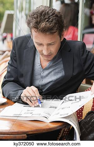 Man reading a magazine in a restaurant, Paris, Ile-de-France, France View Large Photo Image Stock Image - Man reading a magazine in a restaurant, Paris, Ile-de-France, France. Fotosearch
