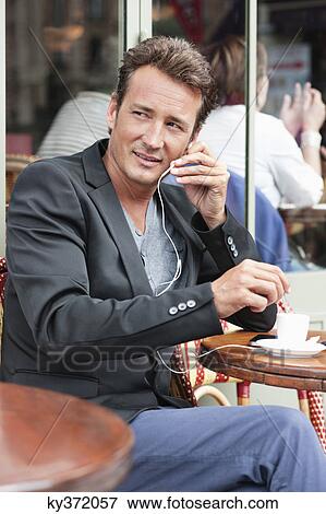 Man talking on a mobile phone in a restaurant, Paris, Ile-de-France, France View Large Photo Image Stock Photo - Man talking on a mobile phone in a restaurant, Paris, Ile-de-France, France. Fotosearch