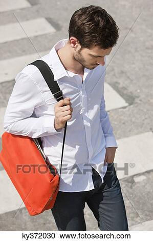 Stock Image - Man walking on crosswalk, Paris, Ile-de-France, France. Fotosearch