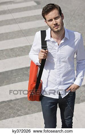 Stock Photograph - Man walking on crosswalk, Paris, Ile-de-France, France. Fotosearch