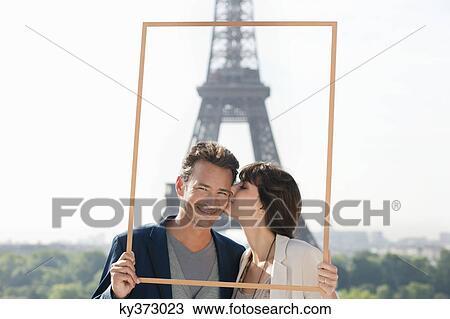 Stock Image - Couple framing their dream vacation with Eiffel Tower in the background, Paris, Ile-de-France, France. Fotosearch