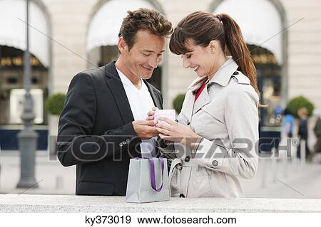 Stock Photo - Couple holding a present, Paris, Ile-de-France, France. Fotosearch