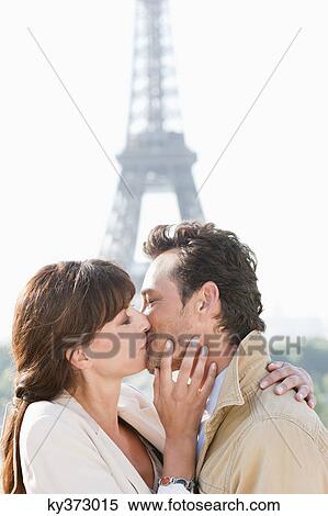 Stock Photography - Couple kissing with the Eiffel Tower in the background, Paris, Ile-de-France, France. Fotosearch