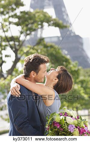 Stock Image - Romantic couple with the Eiffel Tower in the background, Paris, Ile-de-France, France. Fotosearch