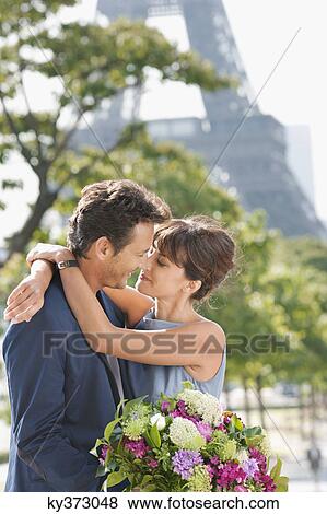Romantic couple with the Eiffel Tower in the background, Paris, Ile-de-France, France View Large Photo Image Stock Photo - Romantic couple with the Eiffel Tower in the background, Paris, Ile-de-France, France. Fotosearch