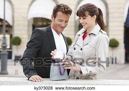 Stock Photo - Woman looking at a present, Paris, Ile-de-France, France. Fotosearch