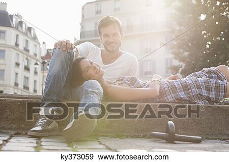 Woman lying on lap of a man at the ledge of a canal, Paris, Ile-de-France, France View Large Photo Image Stock Photo - Woman lying on lap of a man at the ledge of a canal, Paris, Ile-de-France, France. Fotosearch