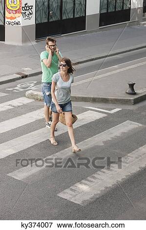 Stock Photo - Couple walking on a road, Paris, Ile-de-France, France. Fotosearch