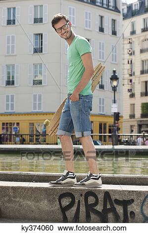 Man carrying a skateboard on the ledge of a canal, Canal St Martin, Paris, Ile-de-France, France View Large Photo Image Stock Image - Man carrying a skateboard on the ledge of a canal, Canal St Martin, Paris, Ile-de-France, France. Fotosearch