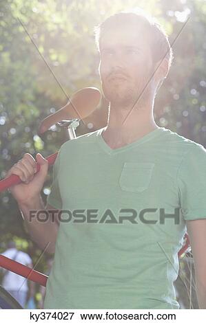 Stock Photo - Man carrying a sports bicycle on his shoulders, Paris, Ile-de-France, France. Fotosearch