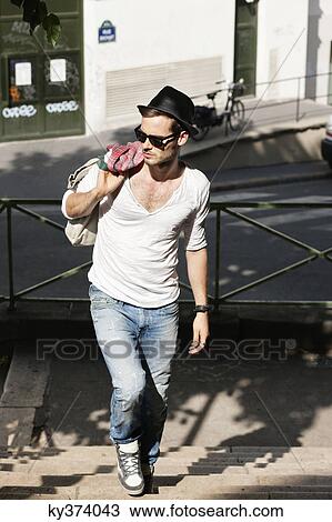Stock Image - Man moving up staircases, Paris, Ile-de-France, France. Fotosearch