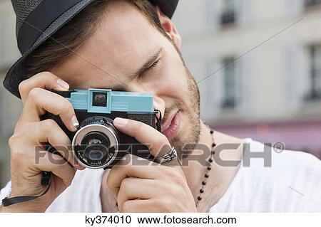 Stock Image - Man photographing with a camera, Paris, Ile-de-France, France. Fotosearch
