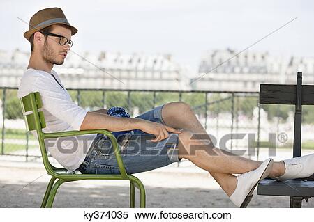 Stock Photography - Man resting in a chair, Jardin des Tuileries, Paris, Ile-de-France, France. Fotosearch