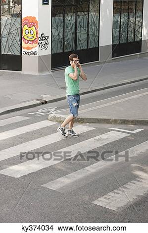 Man talking on a mobile phone on the road, Paris, Ile-de-France, France View Large Photo Image Picture - Man talking on a mobile phone on the road, Paris, Ile-de-France, France. Fotosearch