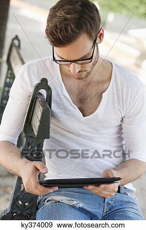 Man using a digital tablet, Paris, Ile-de-France, France View Large Photo Image Stock Photo - Man using a digital tablet, Paris, Ile-de-France, France. Fotosearch