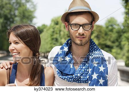Stock Image - Man with his arm around a woman smiling, Paris, Ile-de-France, France. Fotosearch