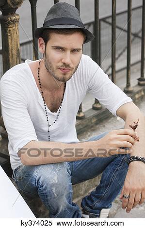 Portrait of a man sitting at the roadside, Paris, Ile-de-France, France View Large Photo Image Stock Photography - Portrait of a man sitting at the roadside, Paris, Ile-de-France, France. Fotosearch