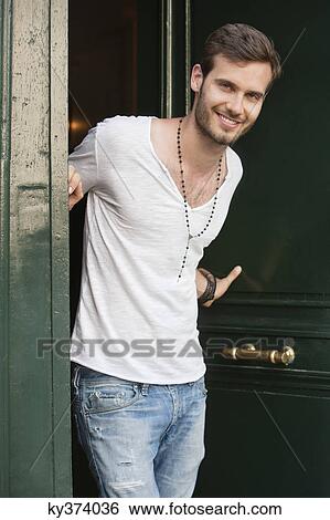 Portrait of a man standing at the doorway and smiling, Paris, Ile-de-France, France View Large Photo Image Stock Photograph - Portrait of a man standing at the doorway and smiling, Paris, Ile-de-France, France. Fotosearch