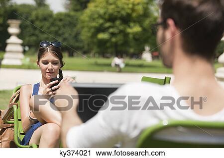 Woman text messaging with a mobile phone, Jardin des Tuileries, Paris, Ile-de-France, France View Large Photo Image Stock Image - Woman text messaging with a mobile phone, Jardin des Tuileries, Paris, Ile-de-France, France. Fotosearch