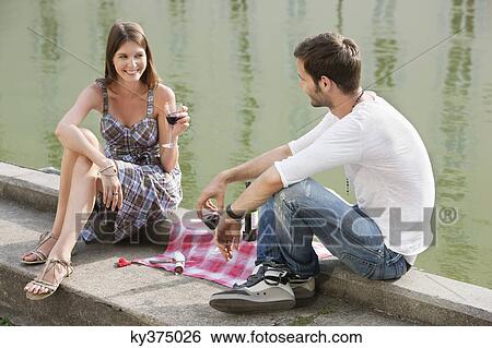 Couple drinking red wine at the ledge of a canal, Paris, Ile-de-France, France View Large Photo Image Stock Photograph - Couple drinking red wine at the ledge of a canal, Paris, Ile-de-France, France. Fotosearch