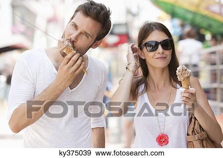 Stock Photo - Couple eating ice creams, Paris, Ile-de-France, France. Fotosearch