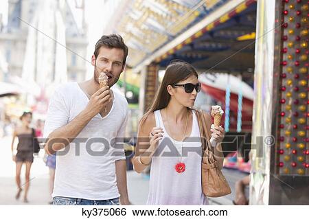 Stock Photograph - Couple eating ice creams, Paris, Ile-de-France, France. Fotosearch