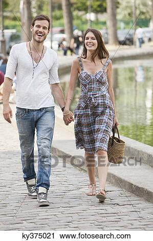Couple walking near a canal and smiling, Paris, Ile-de-France, France View Large Photo Image Stock Image - Couple walking near a canal and smiling, Paris, Ile-de-France, France. Fotosearch