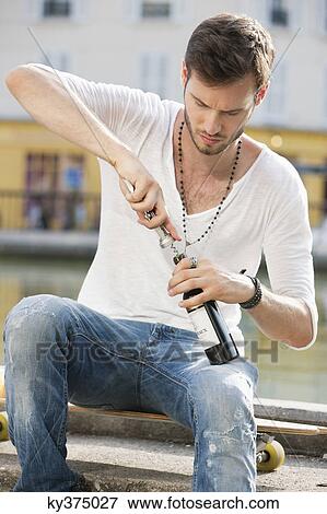 Man opening a wine bottle with a corkscrew, Paris, Ile-de-France, France View Large Photo Image Stock Photo - Man opening a wine bottle with a corkscrew, Paris, Ile-de-France, France. Fotosearch