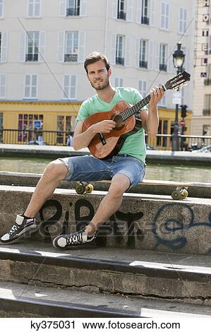 Man playing a guitar, Canal St Martin, Paris, Ile-de-France, France View Large Photo Image Stock Image - Man playing a guitar, Canal St Martin, Paris, Ile-de-France, France. Fotosearch