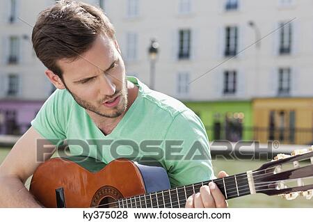 Man playing a guitar, Canal St Martin, Paris, Ile-de-France, France View Large Photo Image Stock Photo - Man playing a guitar, Canal St Martin, Paris, Ile-de-France, France. Fotosearch