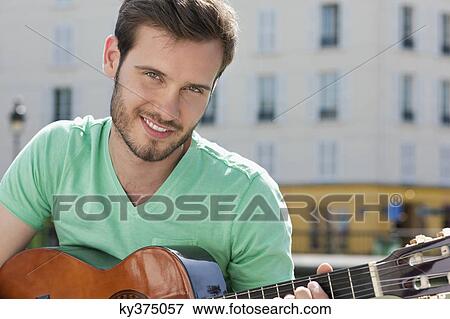 Man playing a guitar, Canal St Martin, Paris, Ile-de-France, France View Large Photo Image Stock Photo - Man playing a guitar, Canal St Martin, Paris, Ile-de-France, France. Fotosearch