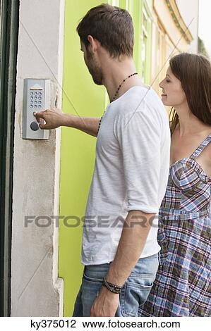 Stock Image - Man ringing a doorbell, Paris, Ile-de-France, France. Fotosearch