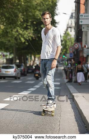 Picture - Man skateboarding on the road, Paris, Ile-de-France, France. Fotosearch