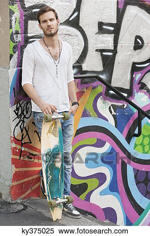 Portrait of a man holding a skateboard, Paris, Ile-de-France, France View Large Photo Image Stock Photography - Portrait of a man holding a skateboard, Paris, Ile-de-France, France. Fotosearch