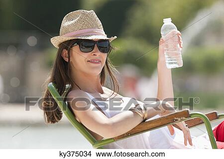 Woman sitting in a chair and drinking water, Bassin octogonal, Jardin des Tuileries, Paris, Ile-de-France, France View Large Photo Image Picture - Woman sitting in a chair and drinking water, Bassin octogonal, Jardin des Tuileries, Paris, Ile-de-France, France. Fotosearch