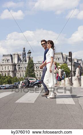 Stock Image - Couple crossing the road, Paris, Ile-de-France, France. Fotosearch