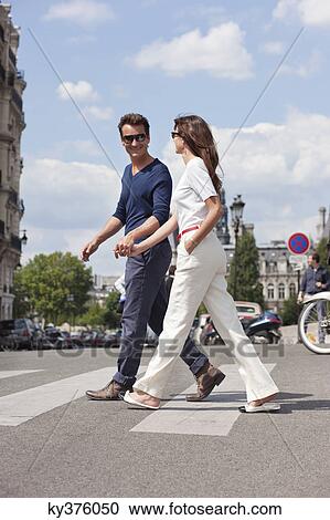 Stock Image - Couple crossing the road, Paris, Ile-de-France, France. Fotosearch