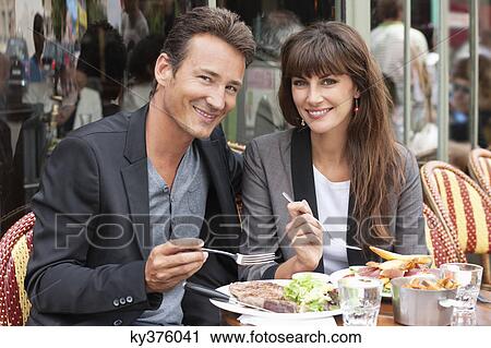 Couple enjoying lunch at a restaurant, Paris, Ile-de-France, France View Large Photo Image Stock Image - Couple enjoying lunch at a restaurant, Paris, Ile-de-France, France. Fotosearch