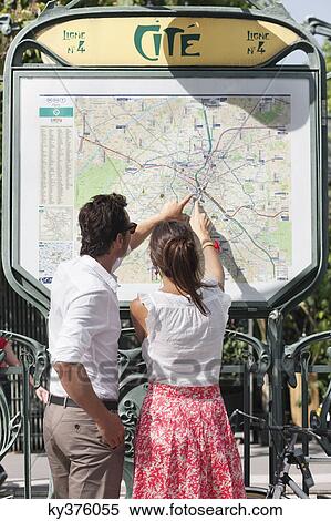 Stock Photography - Couple pointing at a map, Paris, Ile-de-France, France. Fotosearch