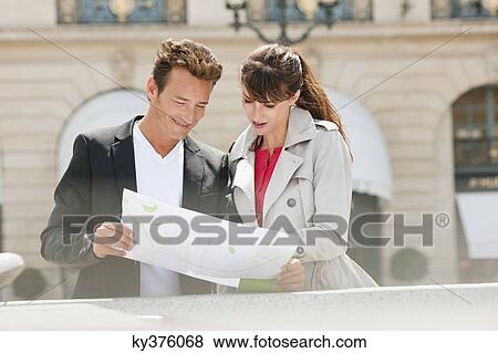 Stock Photo - Couple reading a map, Paris, Ile-de-France, France. Fotosearch